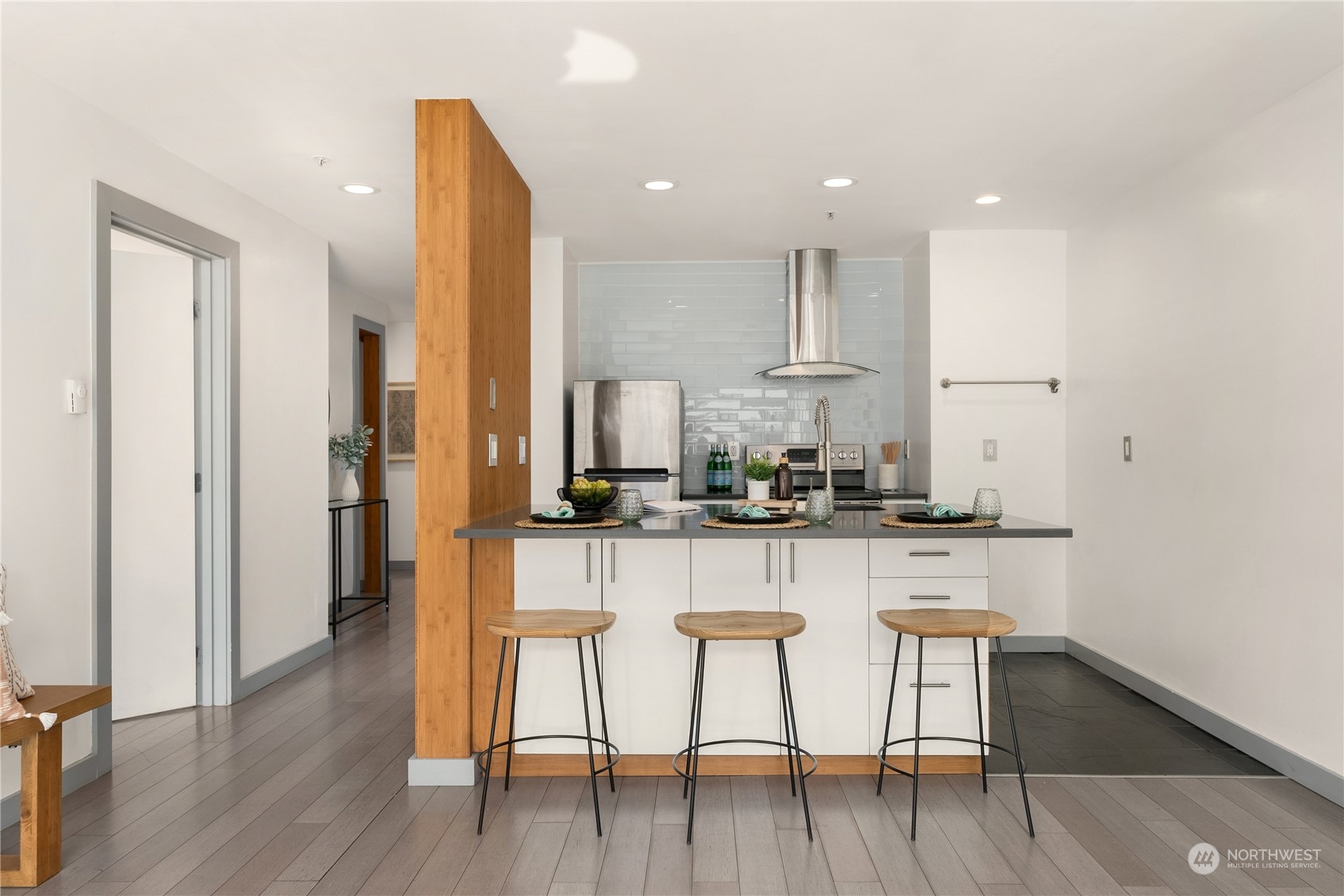 321 10th Avenue South, Unit 508 Seattle, WA 98104 - Photo 6 of 26 a kitchen with stainless steel appliances granite countertop a kitchen island a hardwood floor and chairs