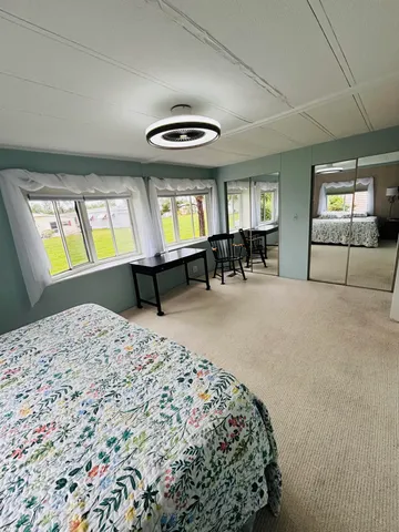 a bedroom with furniture and a large window