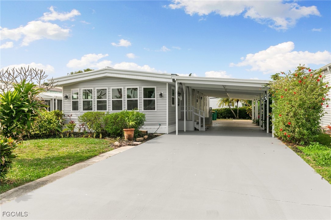 57 San Remo Circle Naples, FL 34112 - Photo 1 of 28 a front view of a house with a yard and potted plants