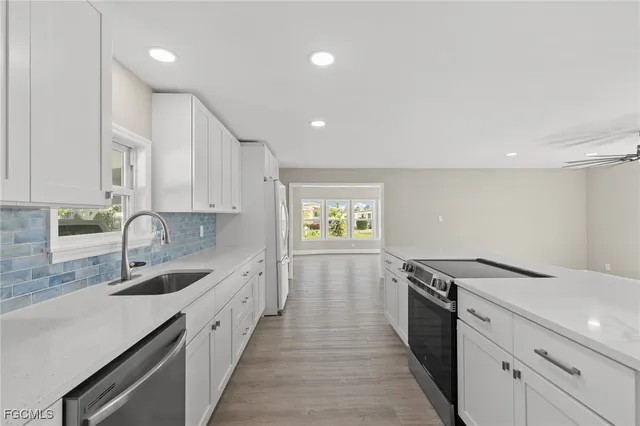 a kitchen with stainless steel appliances granite countertop a stove and a large window