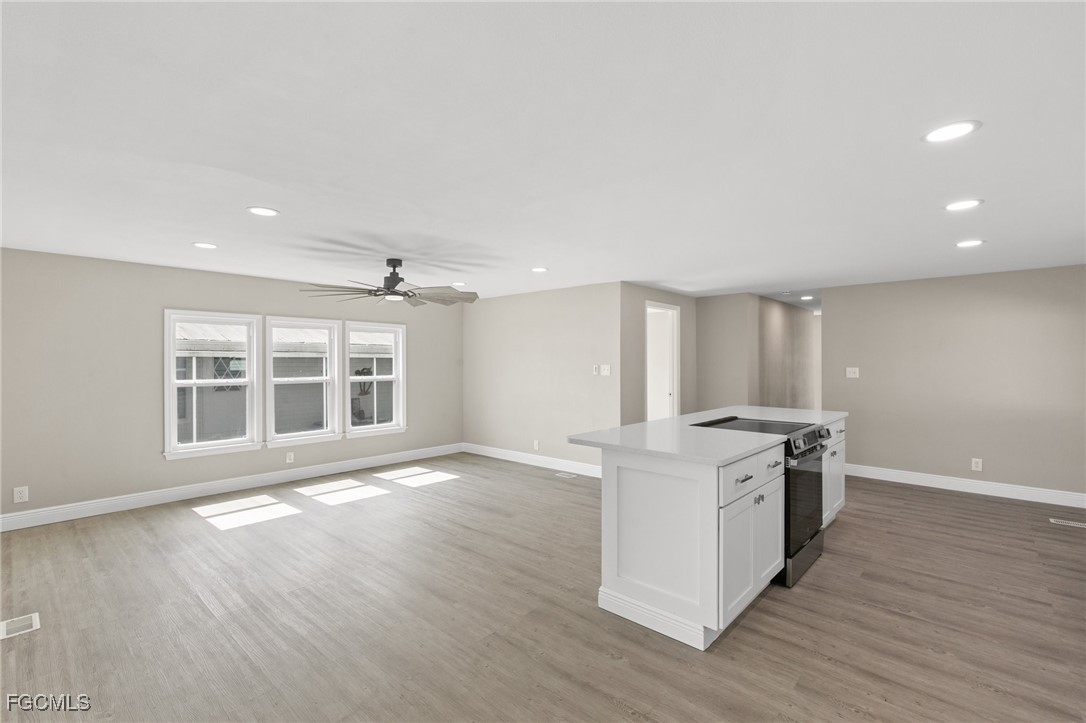 57 San Remo Circle Naples, FL 34112 - Photo 13 of 28 a kitchen with stainless steel appliances granite countertop a stove and a large window