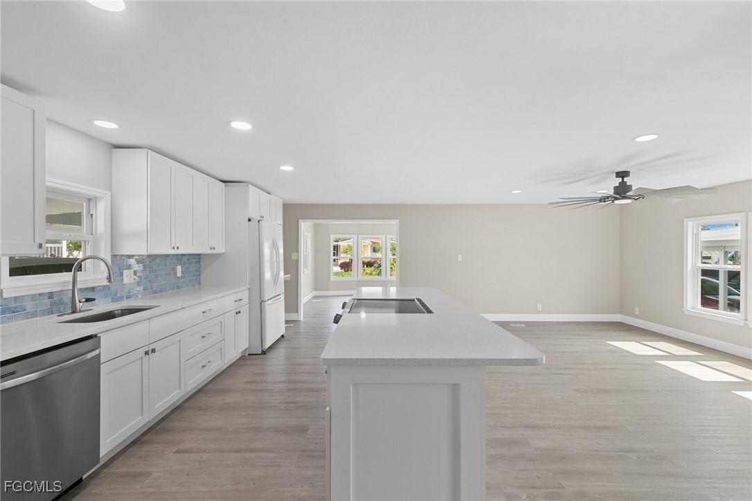 57 San Remo Circle Naples, FL 34112 - Photo 17 of 28 a large white kitchen with a sink and dishwasher stove with wooden floor