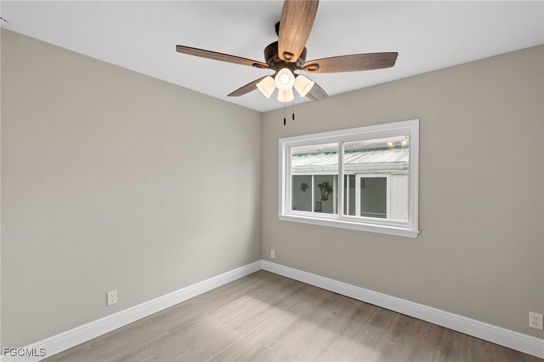 57 San Remo Circle Naples, FL 34112 - Photo 22 of 28 an empty room with a window and a fan