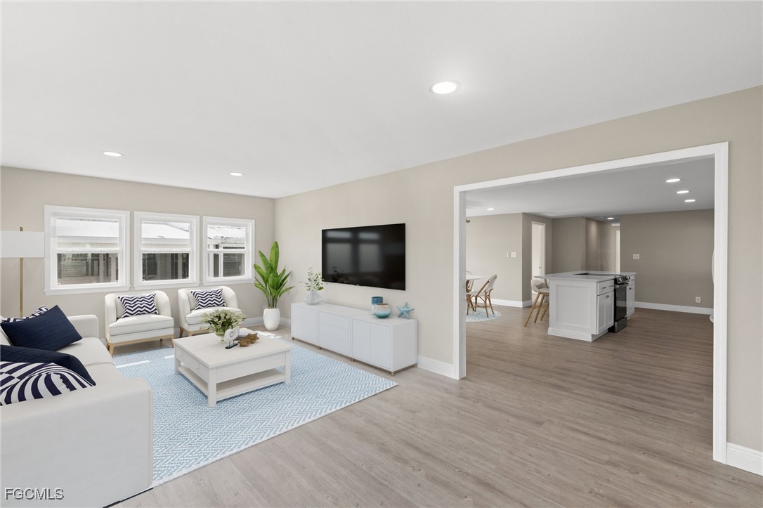 57 San Remo Circle Naples, FL 34112 - Photo 5 of 28 a living room with furniture and a flat screen tv