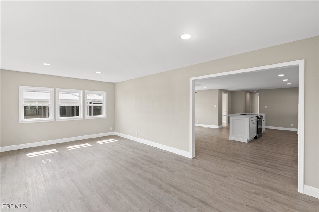 57 San Remo Circle Naples, FL 34112 - Photo 6 of 28 a view of an empty room with wooden floor and a window