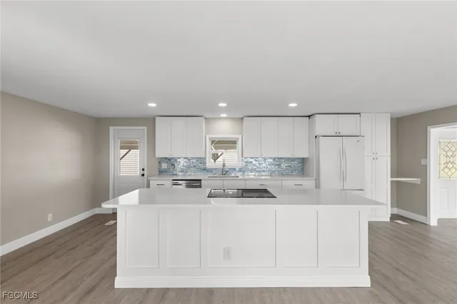 a kitchen with granite countertop white cabinets and white stainless steel appliances