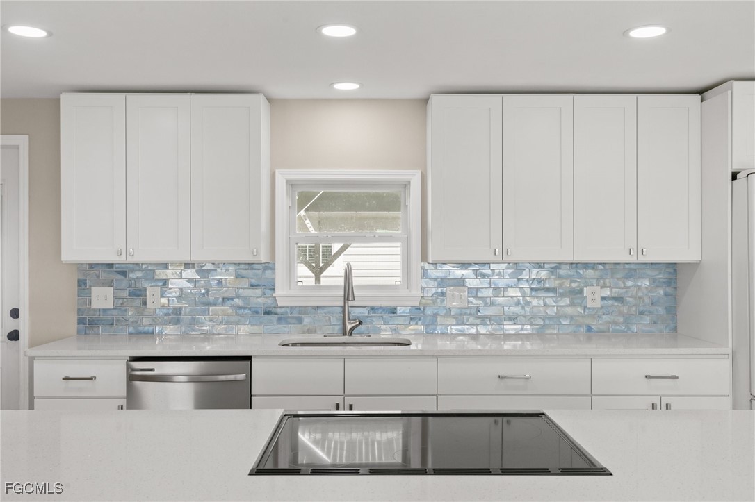 57 San Remo Circle Naples, FL 34112 - Photo 10 of 28 a kitchen with granite countertop white cabinets and white stainless steel appliances