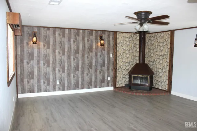 a view of wooden floor and a chandelier fan in a room