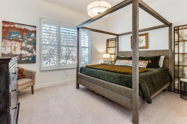 a bedroom with a bed couch and a large window