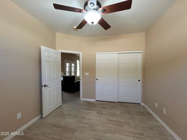 an empty room with closet and a chandelier fan