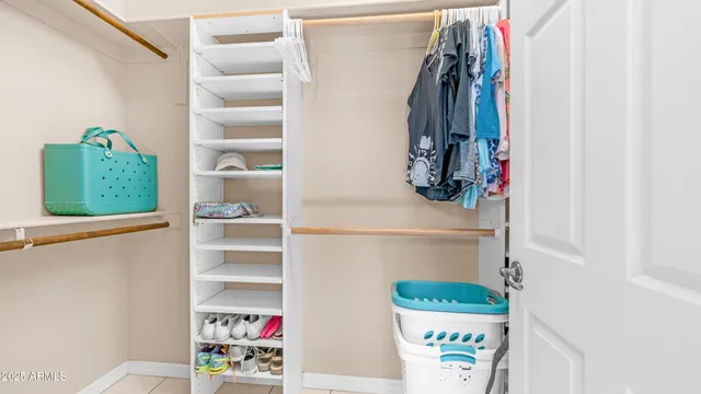 a view of walk in closet with clothes and shoes
