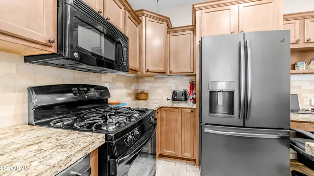 a kitchen with stainless steel appliances granite countertop a refrigerator stove and microwave