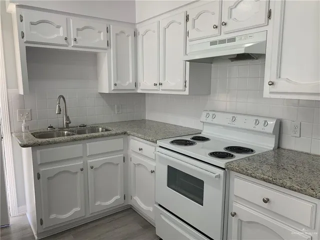 a kitchen with white cabinets and white appliances