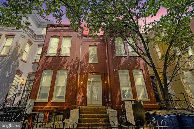 a view of a hallway with wooden floor and cabinet