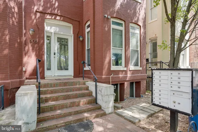 a kitchen with stainless steel appliances granite countertop a white cabinets a sink a stove a refrigerator with white cabinets and wooden floor