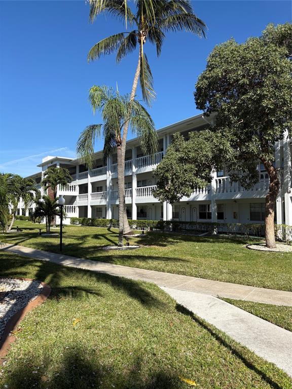 2455 Northeast 51st Street, Unit 207 Fort Lauderdale, FL 33308 - Photo 3 of 6 a view of a house with swimming pool and a yard