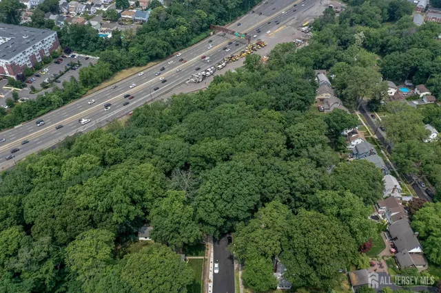 an aerial view of residential house with outdoor space and trees all around