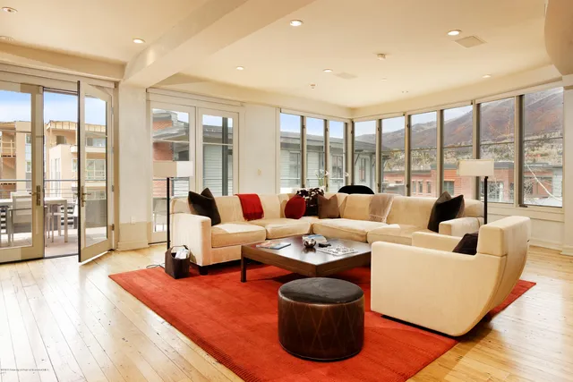 a living room with furniture and a floor to ceiling window