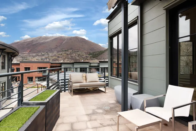 a balcony with furniture and a potted plant