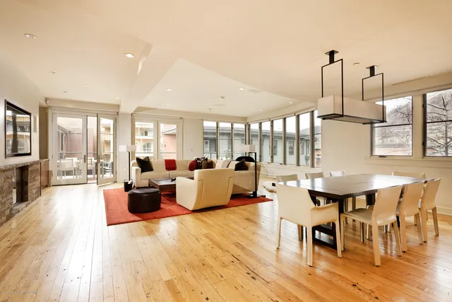 a view of a dining room and livingroom with furniture wooden floor a chandelier