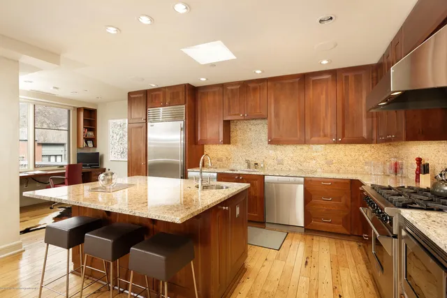 a large kitchen with granite countertop a stove top oven a sink a dining table and chairs