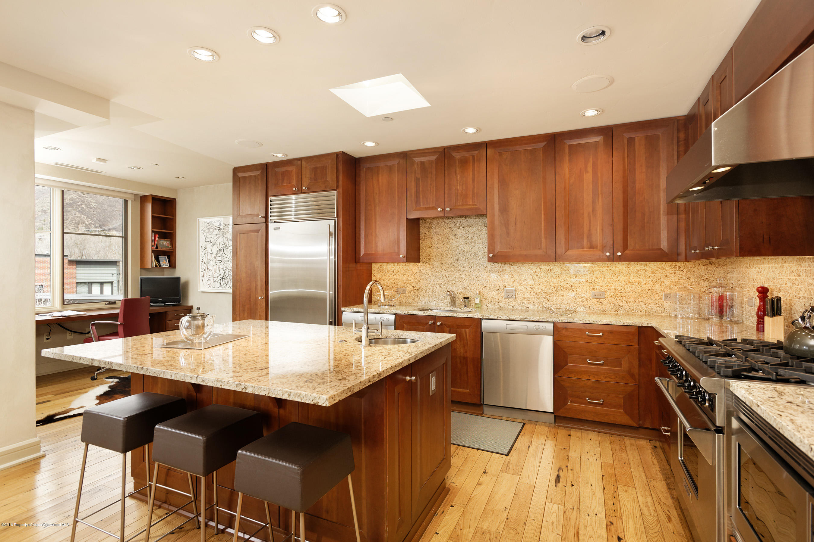 102 Founders Place, Unit 301 Aspen, CO 81611 - Photo 9 of 28 a large kitchen with granite countertop a stove top oven a sink a dining table and chairs