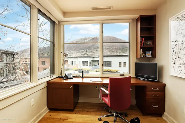a view of a workspace with furniture and a window