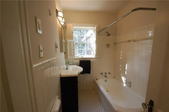 a bathroom with a bathtub shower sink and mirror