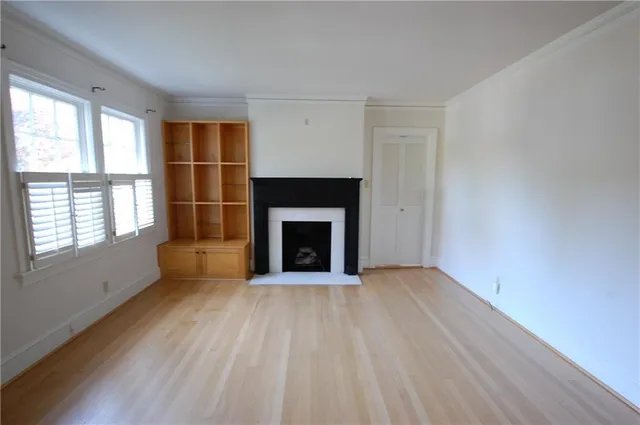 wooden floor fireplace and windows in an empty room