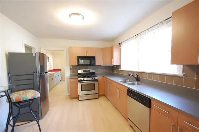 a kitchen with stainless steel appliances a stove a sink and a refrigerator