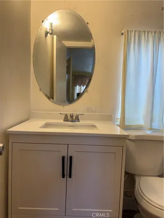 a bathroom with a sink a toilet a mirror and shower