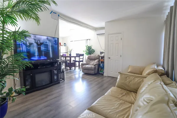 a living room with furniture large window and wooden floor
