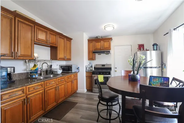 a kitchen with stainless steel appliances granite countertop a stove a sink dishwasher and cabinets with wooden floor