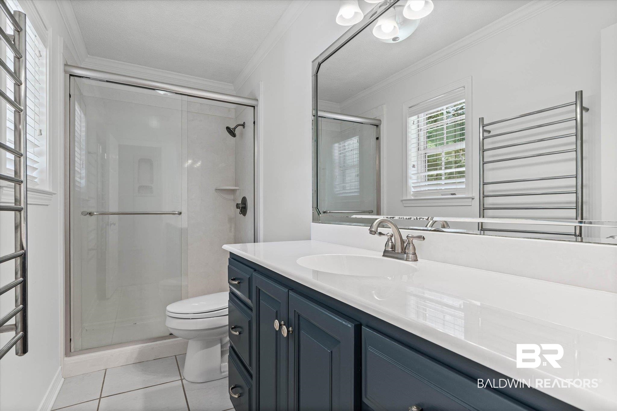 8301 Fordham Road Mobile, AL 36619 - Photo 15 of 57 Bathroom featuring a dark blue vanity cabinet with brushed nickel hardware, a white countertop with an integrated sink, a glass-enclosed shower with dark bronze fixtures, and white tile flooring