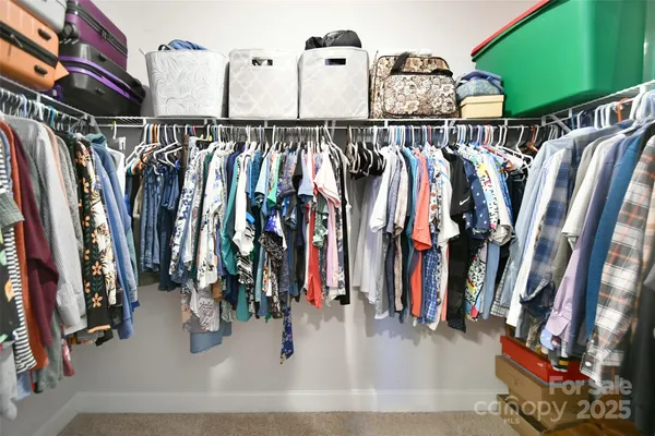 a view of walk in closet with clothes and shoes