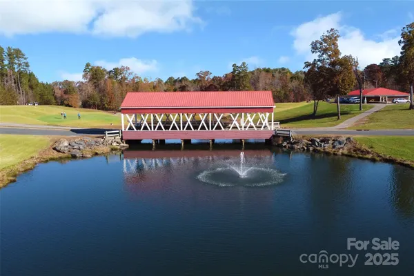 a view of swimming pool with outdoor seating and lake view