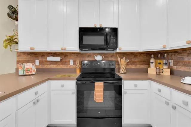 a kitchen with a refrigerator and a stove top oven