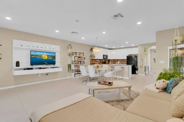a living room with furniture kitchen view and a flat screen tv