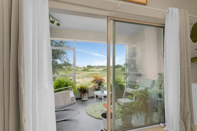a living room with furniture a chandelier and a large window