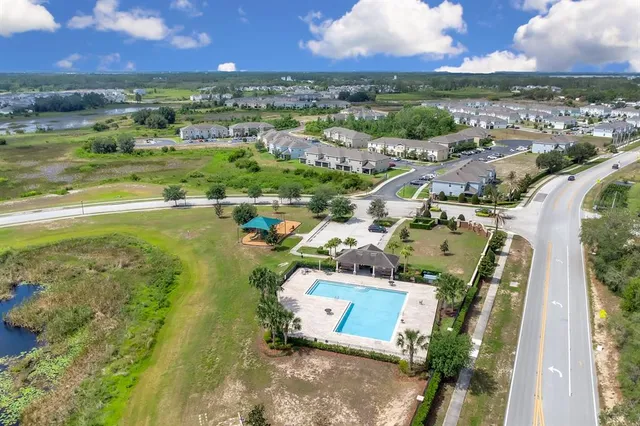 an aerial view of residential houses with outdoor space and ocean view