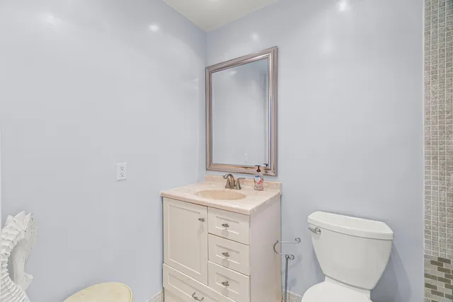 a bathroom with a toilet sink and mirror