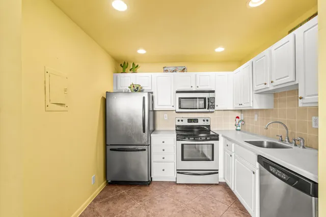 a kitchen with stainless steel appliances a refrigerator sink and microwave
