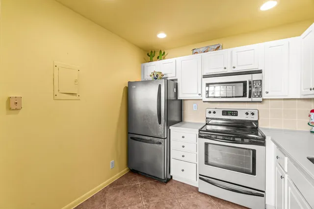 a kitchen with white cabinets and stainless steel appliances