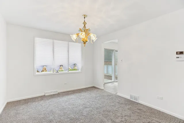 a dining room with furniture a large window and wooden floor