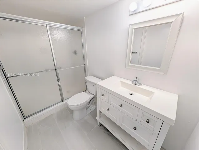 a bathroom with a double vanity sink toilet and shower