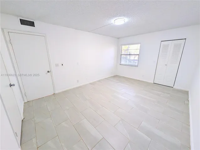 an empty room with windows and closet