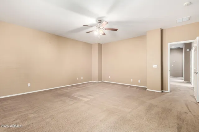 an empty room with closet and a chandelier fan