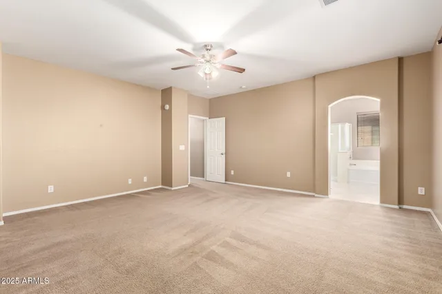 an empty room with closet and a chandelier fan