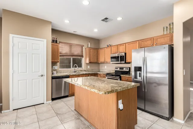 a kitchen with stainless steel appliances granite countertop a refrigerator a sink a stove a microwave and island