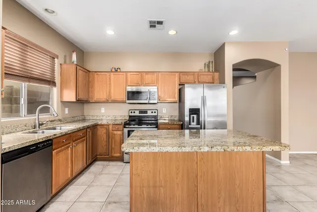 a kitchen with stainless steel appliances granite countertop a sink counter space cabinets and a large window